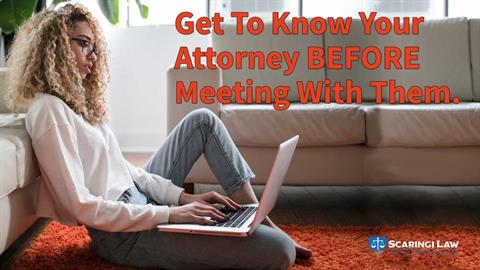 Young woman sitting in living room, researching lawyers on a laptop.