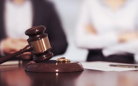 Judge's gavel and wedding rings in a contested divorce