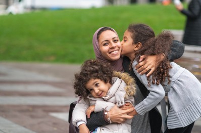 An immigrant family hugging at the park